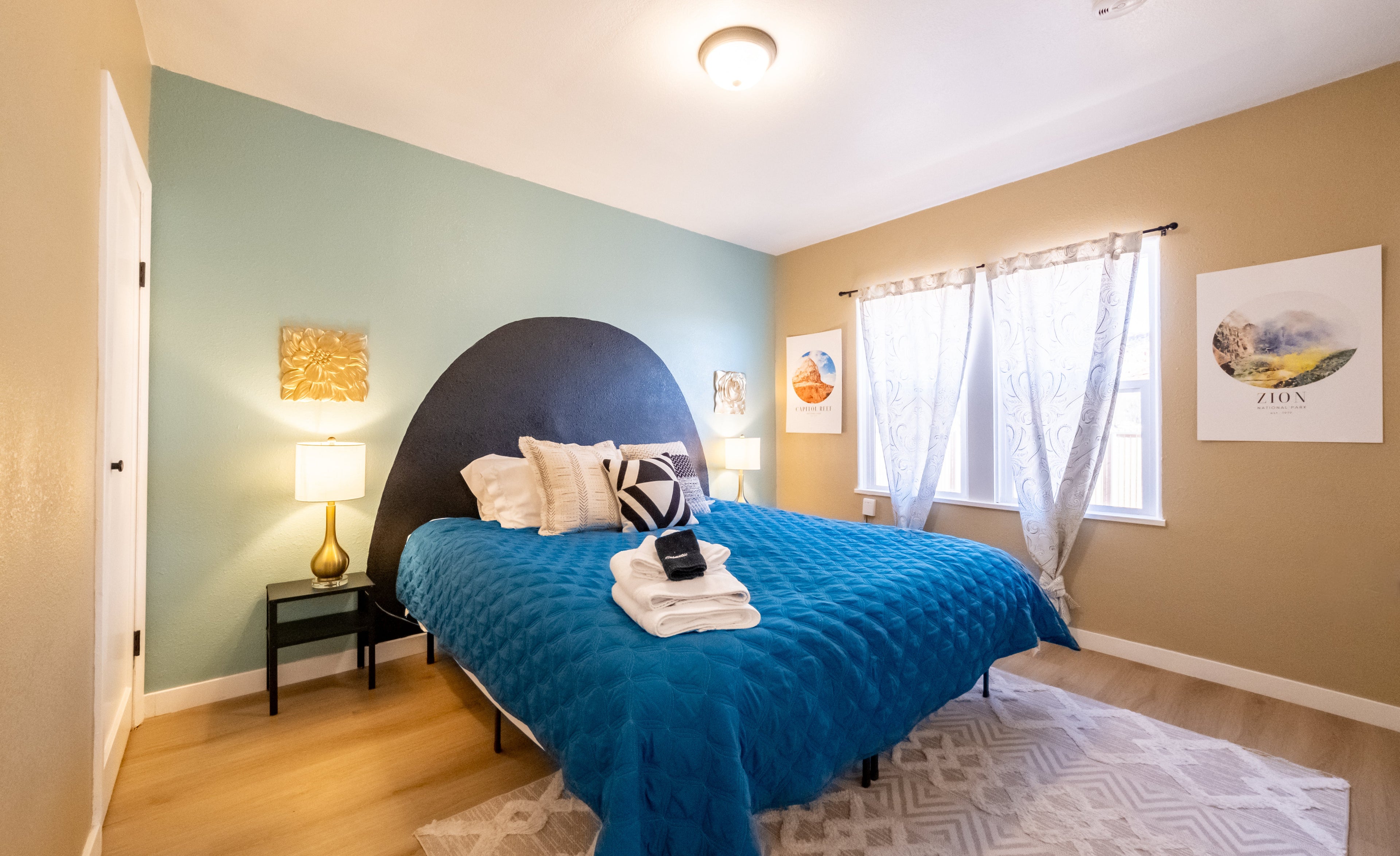 Bedroom with blue bedspread, nightstands, and a lamp.